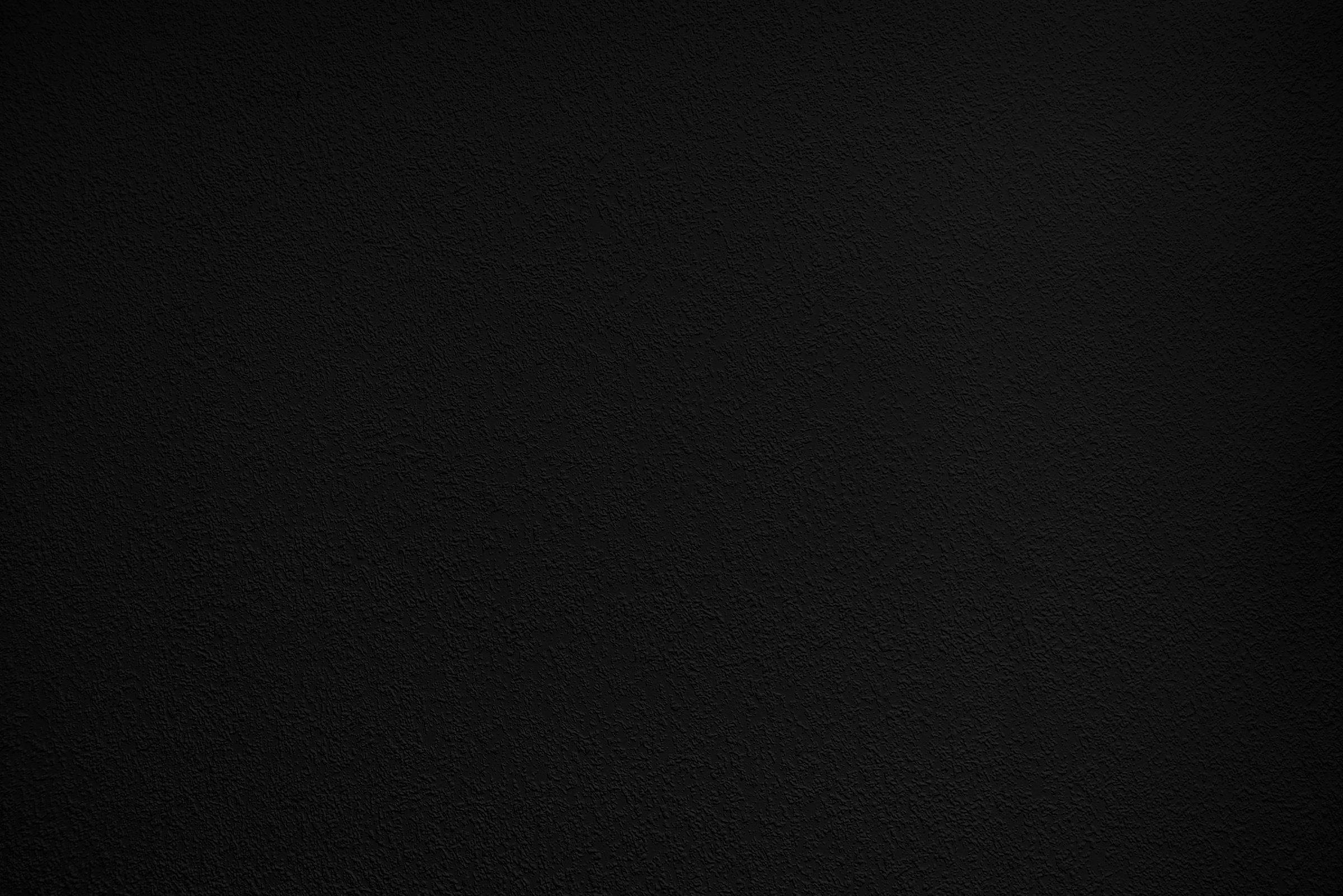 Black Background. Dark Grainy Texture. Wall Surface in the Dark